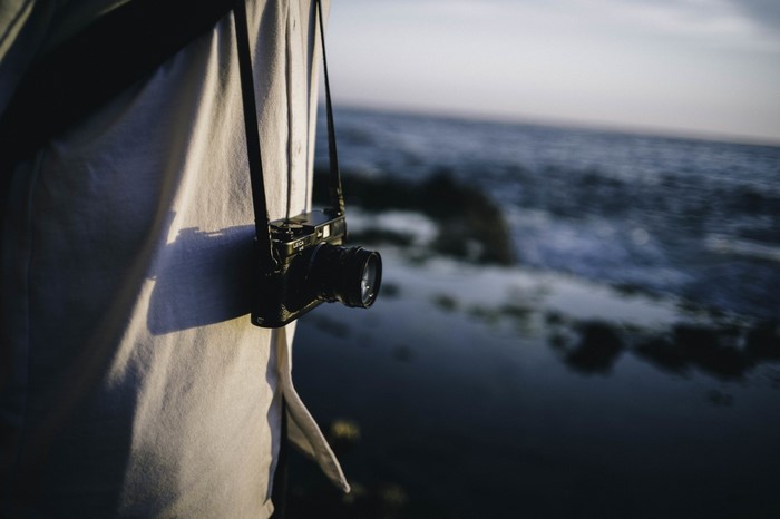 Person with Leica camera by the sea