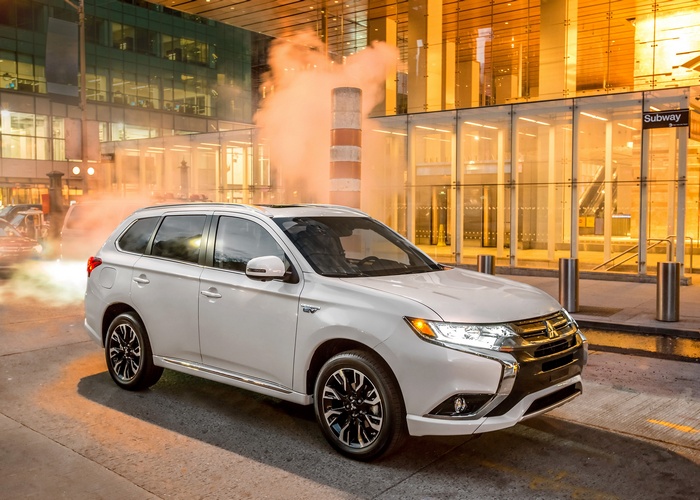 White Mitsubishi Outlander PHEV in front of a building