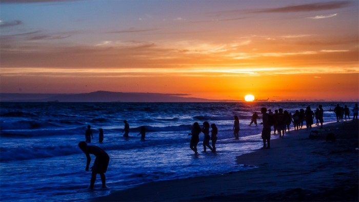 People on a beach at sunset
