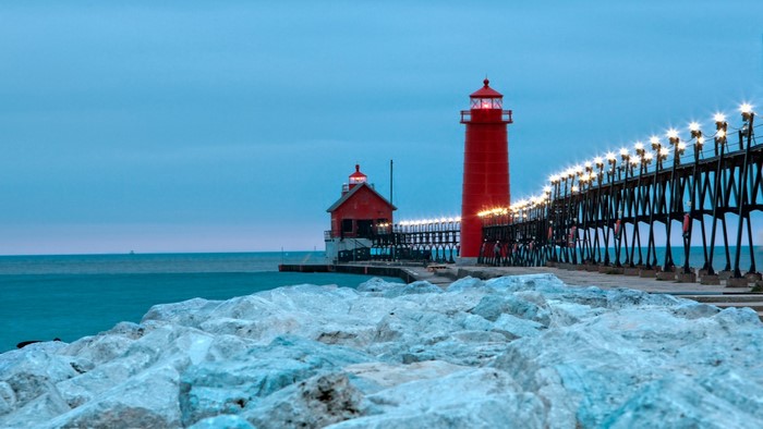 Two red lighthouses and a pier at dusk