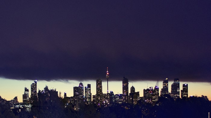 City skyline at night with dark clouds