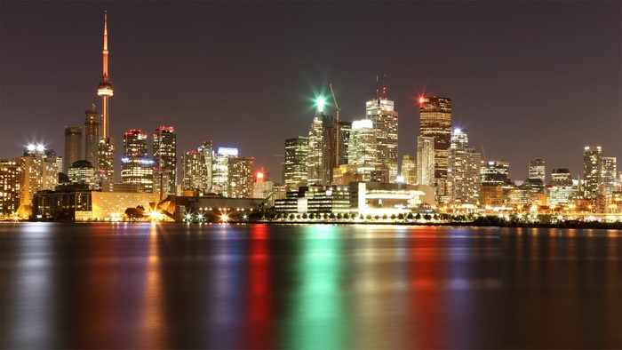 Toronto skyline at night with CN Tower and reflections