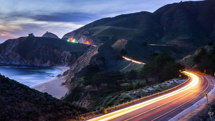Coastal highway at dusk with light trails