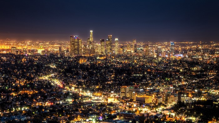 Nighttime cityscape of a sprawling metropolis with illuminated skyscrapers