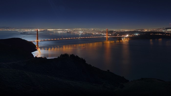Golden Gate Bridge at night with city lights