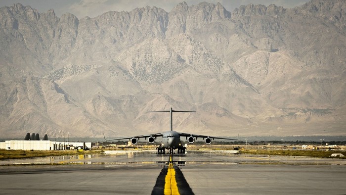 Boeing C-17 Globemaster III on a runway with mountains
