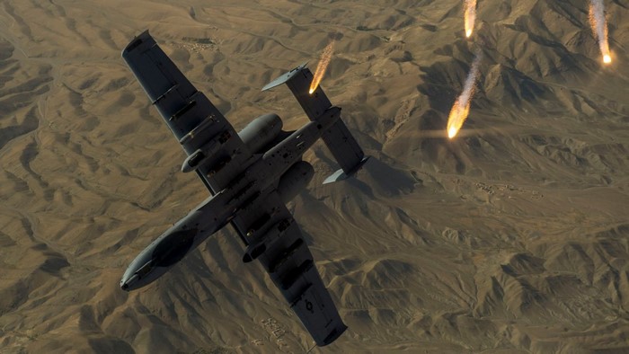 A-10 Thunderbolt II aircraft deploying flares over desert terrain