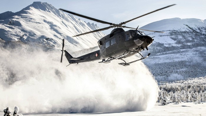 Bell 412 military helicopter in snowy mountains