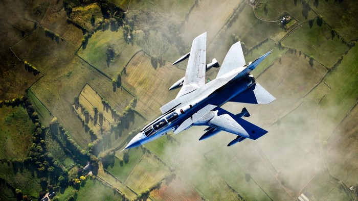Panavia Tornado fighter jet flying over rural landscape