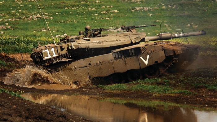 Merkava tank of the Israel Defense Forces driving through mud