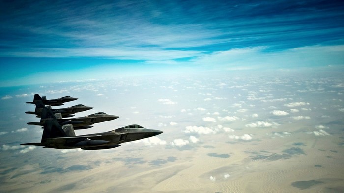 Four F-22 Raptor fighter jets flying in formation
