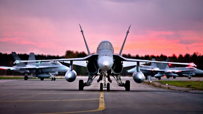 Fighter jets on a runway at sunset