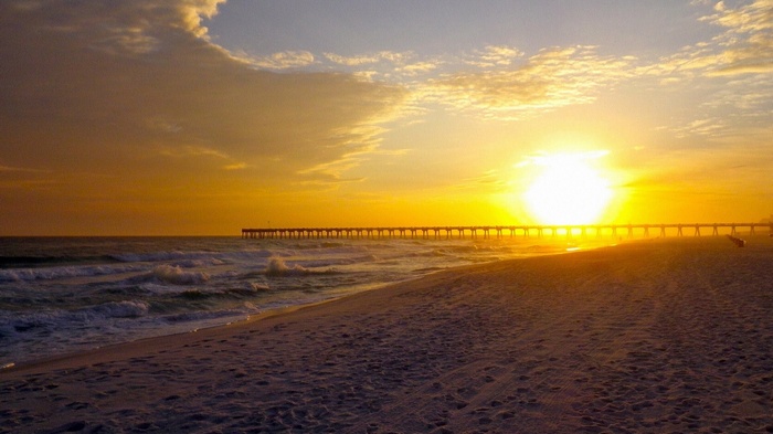 Sunset over the ocean with a pier