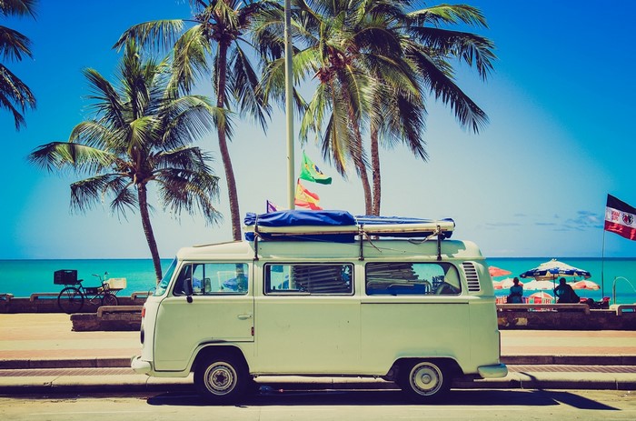 Vintage van parked by the beach with palm trees