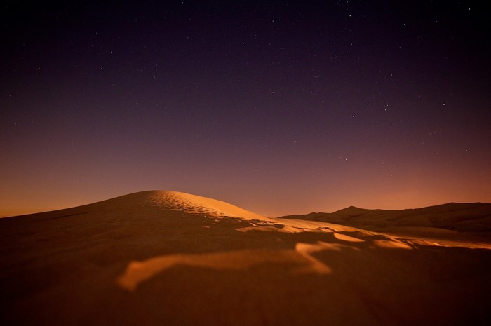 Desert dunes under a starry night sky