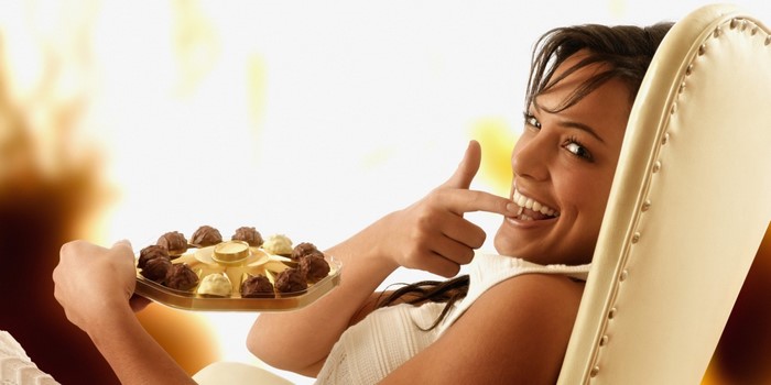 Woman eating chocolates from a tray