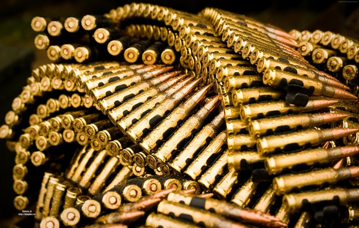 A pile of gold bullets with water droplets
