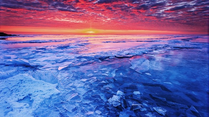 Sunset over a frozen sea with ice formations