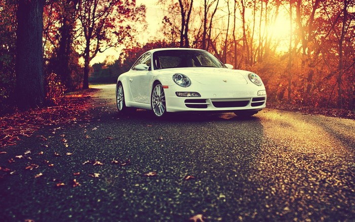 White Porsche sports car on a road during sunset