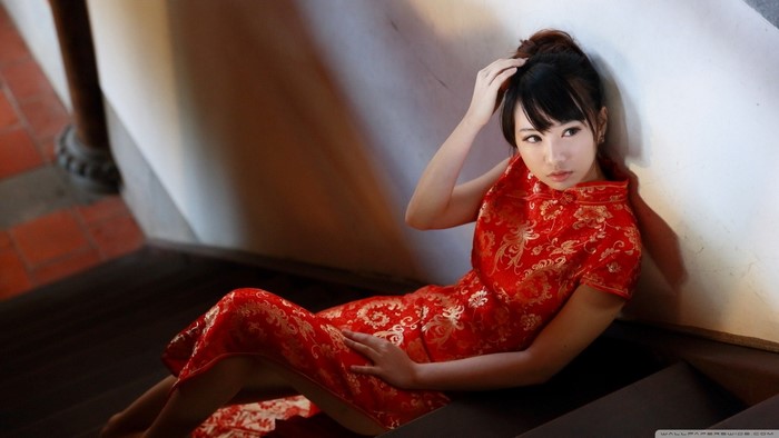 Asian woman in red dress sitting on stairs