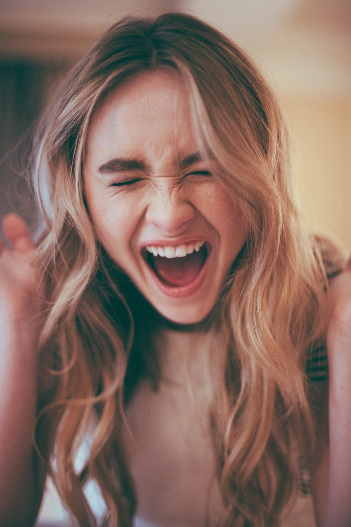 Sabrina Carpenter laughing with eyes closed