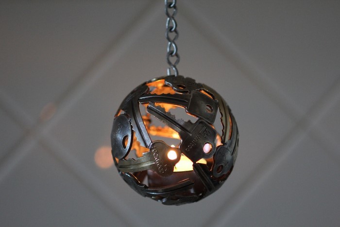 Hanging sphere lantern made of keys with candle