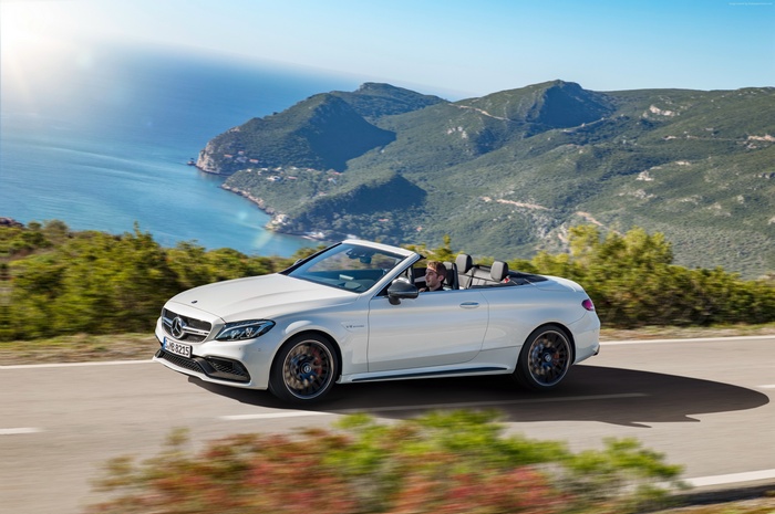 White Mercedes-AMG C 63 S Cabriolet driving on coastal road