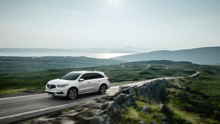 White Acura MDX crossover driving on a scenic mountain road