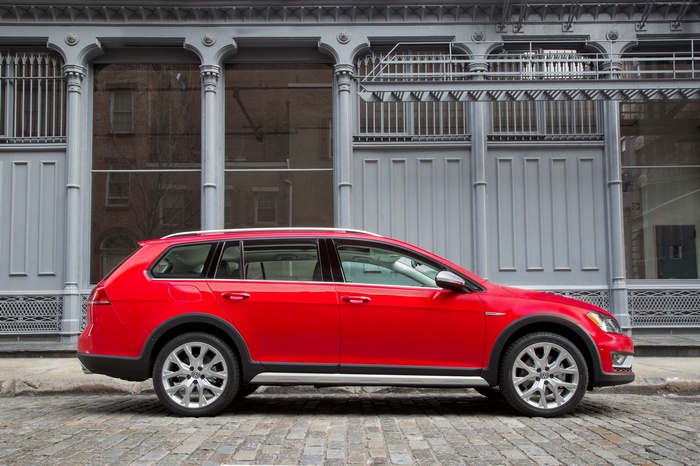 Red Volkswagen Golf Alltrack parked on cobblestone street