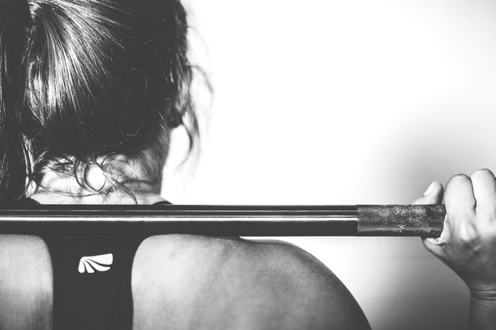 Woman holding a barbell on her shoulders