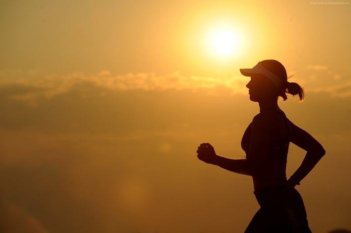 Silhouette of a woman running at sunset