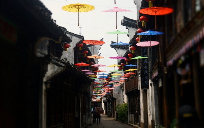 Colorful umbrellas over a street in an Asian city
