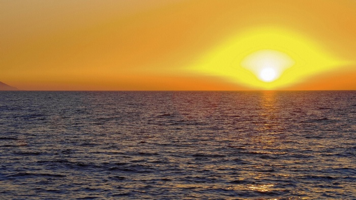 Sunset over the ocean with a distant island