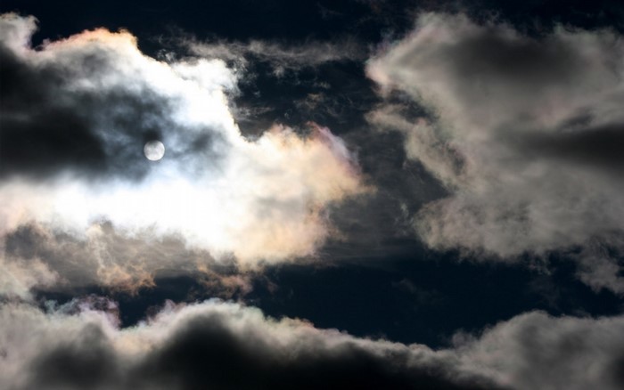 Sun peeking through dark clouds