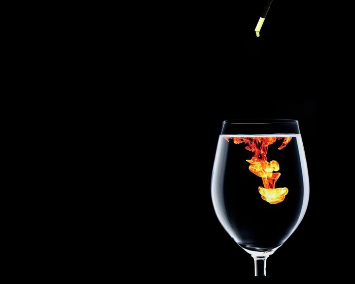 Ink dropping into a wine glass