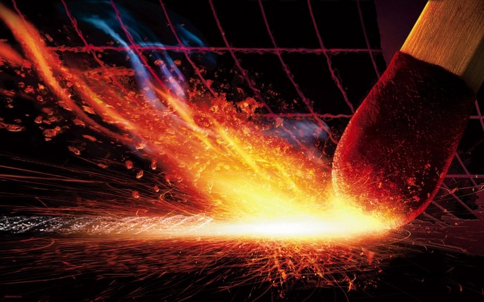 Close-up of a burning match igniting sparks