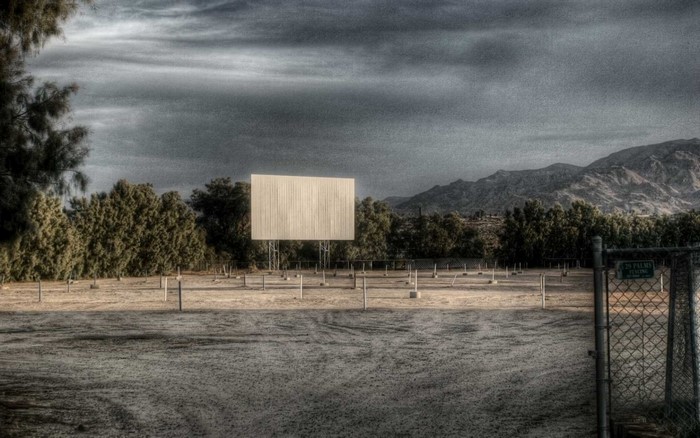 Drive-in movie theater screen with mountains in the background