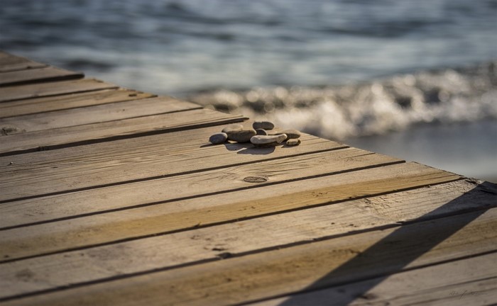 Pebbles on a wooden dock by the sea