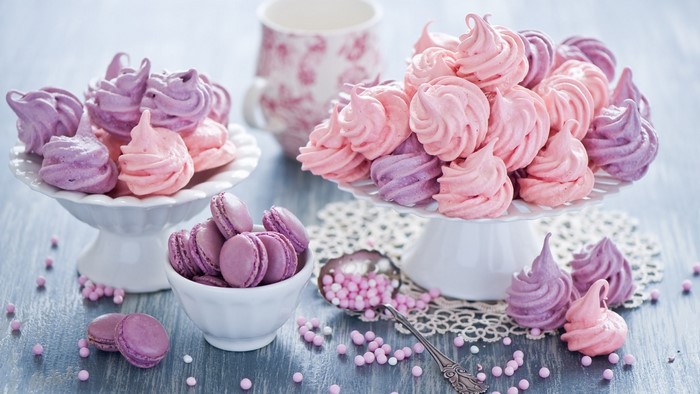 Pink and purple meringues and macarons on cake stands