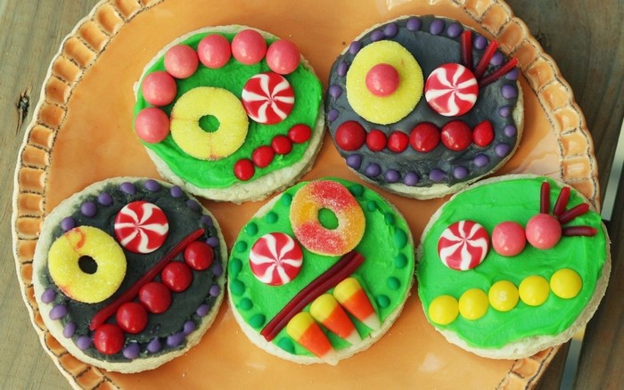 Decorated cookies with candy on an orange plate