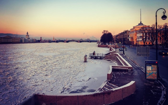 Frozen river in a city at sunset
