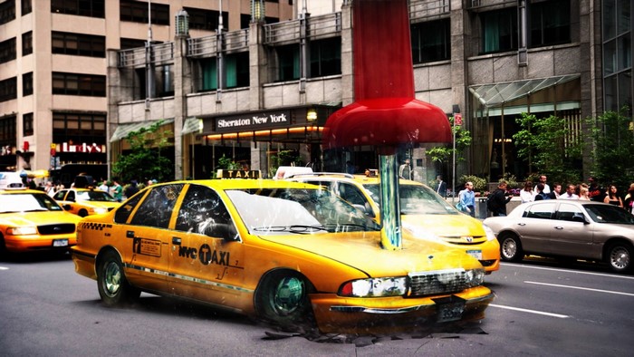 Giant red thumbtack impaling a yellow NYC taxi