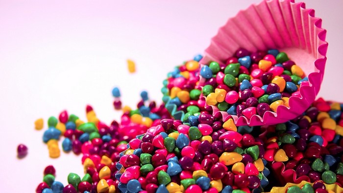 Colorful candies spilling from pink cupcake liners