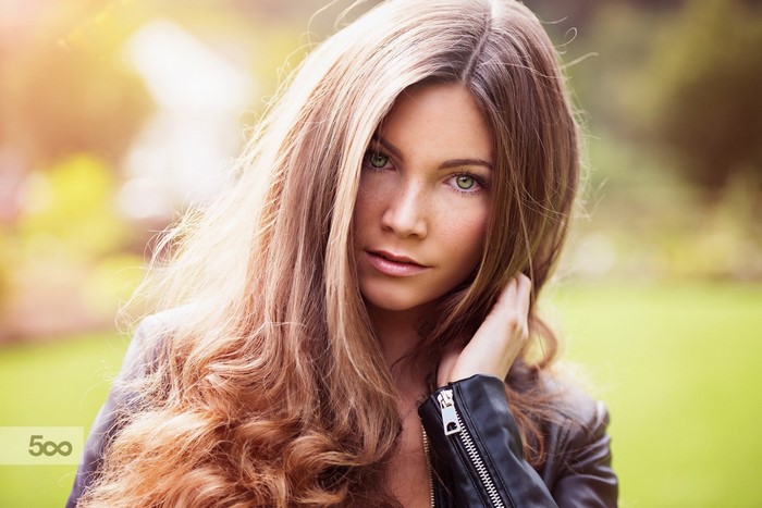 Woman with long wavy brown hair and green eyes