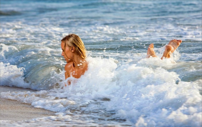 Woman playing in ocean waves at the beach