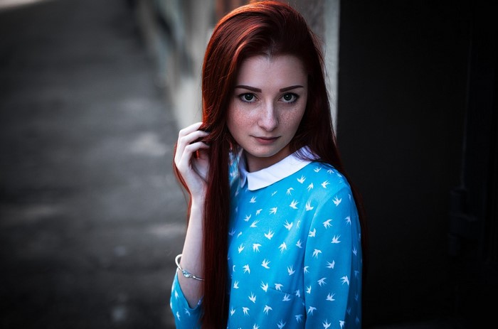 Redhead woman with freckles in a blue dress