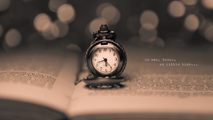 Pocket watch on an open book with bokeh