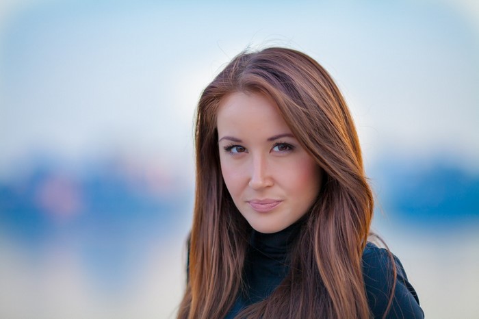 Woman with long brown hair wearing a black turtleneck