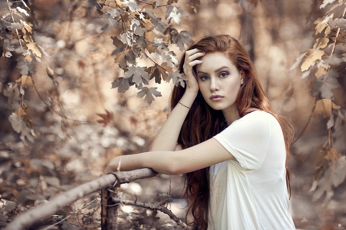 Woman with long red hair posing outdoors