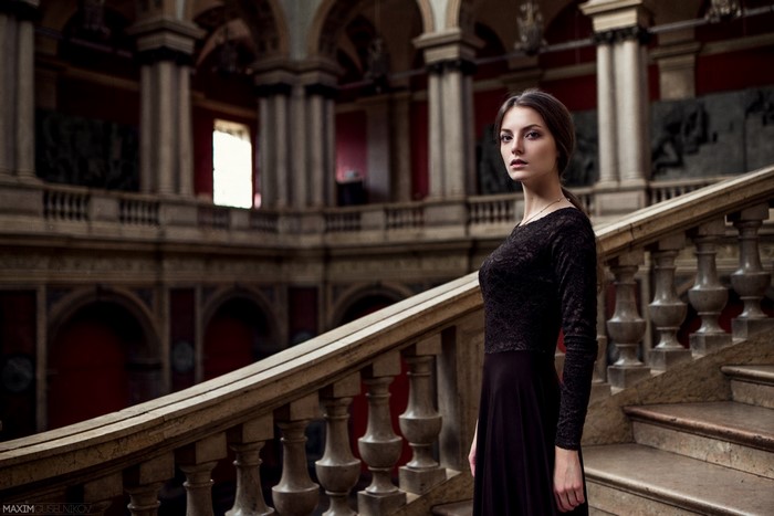 Woman in black dress on ornate staircase